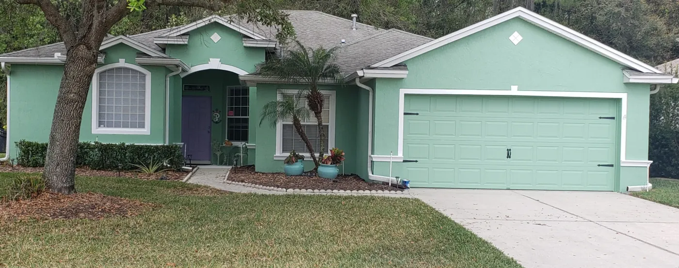 Lakeland FL home after exterior repaint in coastal green with crisp white trim by John Crouthers Painting