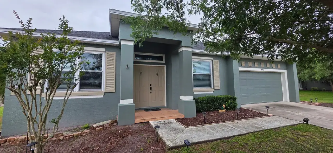 Same Lakeland FL home after exterior repaint in modern teal and cream by John Crouthers Painting