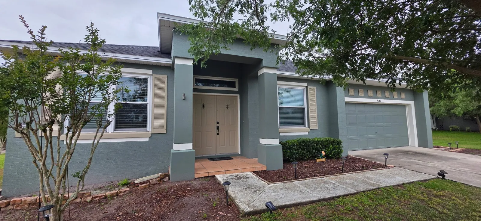 Same Lakeland FL home after exterior repaint in modern teal and cream by John Crouthers Painting