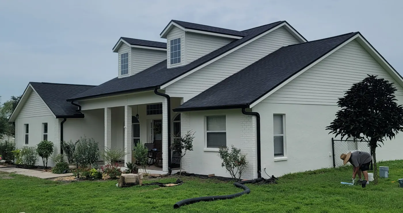 Two-story Polk County FL home after full exterior repaint in warm white with black trim by John Crouthers Painting